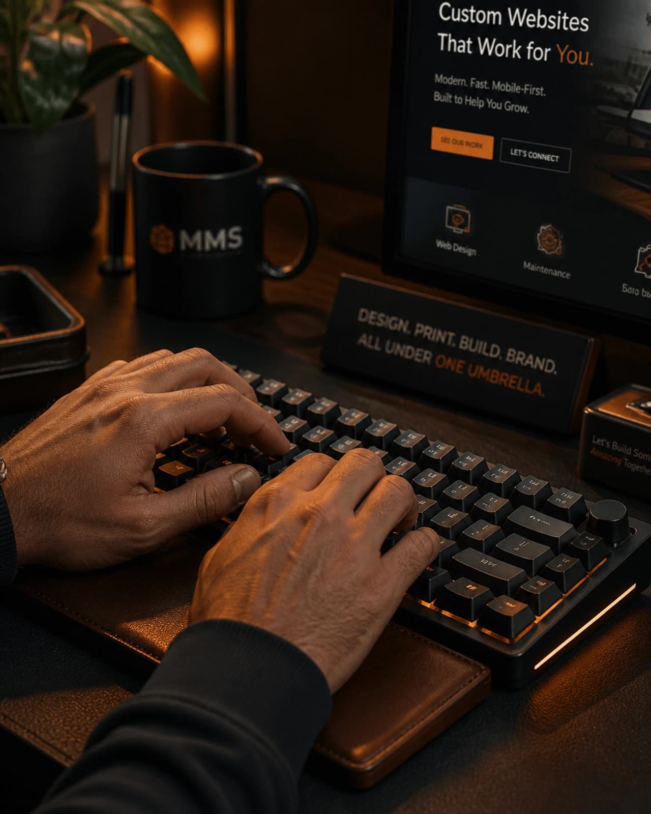 Close-up of hands typing on a modern keyboard in a warm, dark-themed home office environment